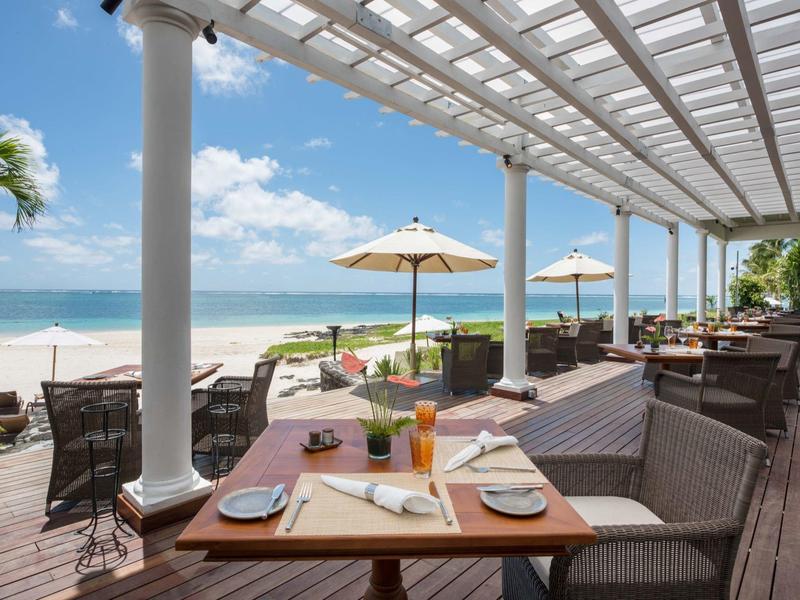 Terasa s posezením a výhledem na moře pod modrou oblohou na pláži.