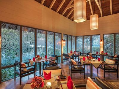 Elegantní hotelová lounge s dřevěnou podlahou, velkými okny a moderním osvětlením.