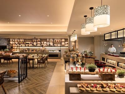 Elegantní hotelová bufetová část s různými jídly a moderním interiérem.