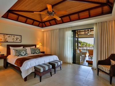 Gezellige hotelkamer met houten plafond, groot bed, lampen en balkon met uitzicht buiten.