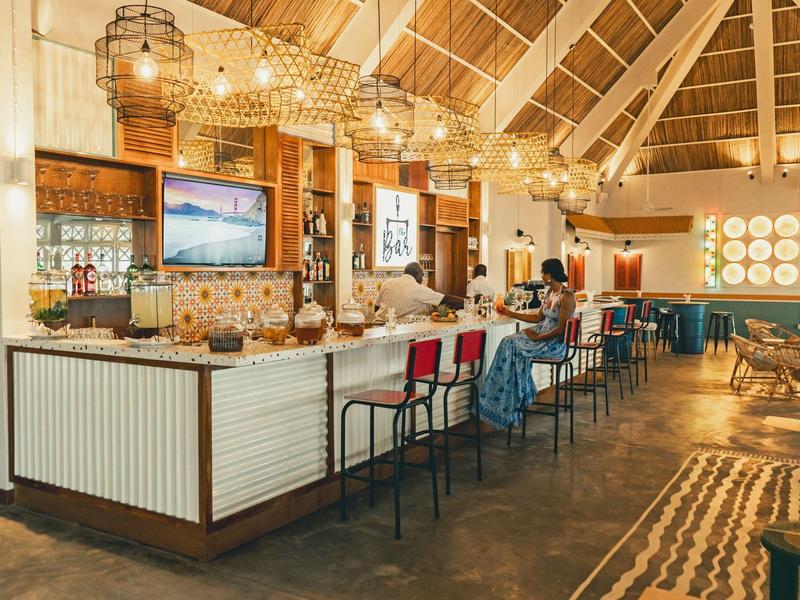 Licht, modern hotelrestaurant met hoge plafonds, bar en gezellige sfeer.