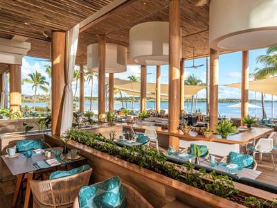 Moderner, offener Restaurantbereich mit Holzmöbeln und Meerblick