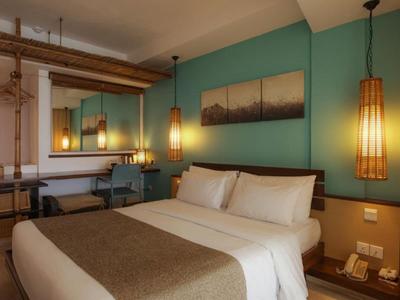 Gemütliches Hotelzimmer mit Doppelbett, warmem Licht und entspanntem Ambiente.