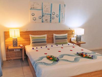 Gemütliches Schlafzimmer mit Doppelbett, Holzkopfteil, zwei Nachttischen und moderner Wanddekoration.