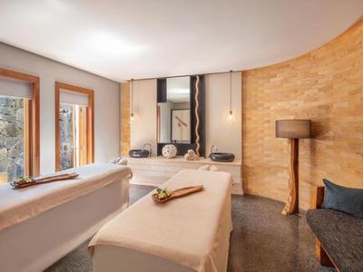 Gezellige wellnessruimte met massagetafels, spiegels en warme houten accenten.