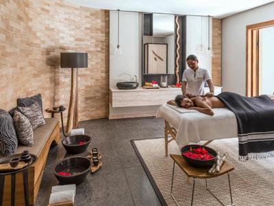 Moderne spa-kamer met massagetafel, voetenbaden en ontspannen sfeer.