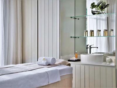 Bright spa room with massage table and modern sink.