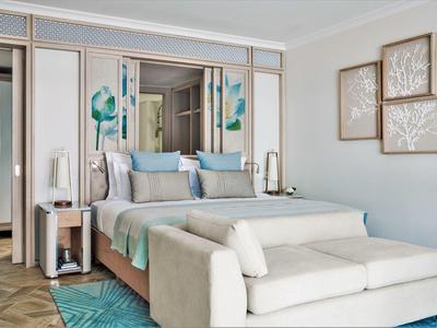 Modern hotel room with cozy bed, sofa, and stylish wall decorations.