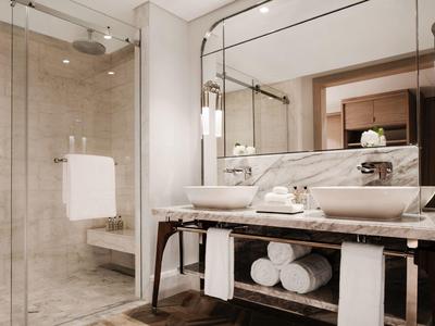 Bright modern bathroom with glass shower, large mirror, and elegant vanity console.