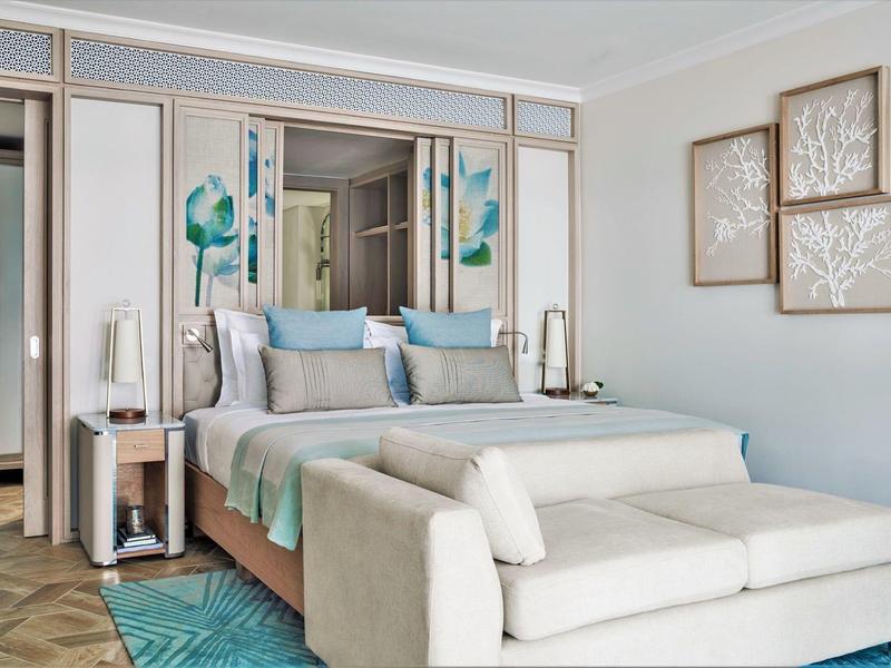 Modern hotel room with cozy bed, sofa, and stylish wall decorations.