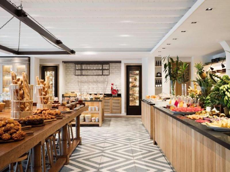 Buffet area with various pastries and fresh fruit in a modern hotel restaurant.