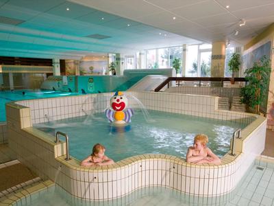Innenpool mit separatem Kinderbecken und buntem Spielzeug in einem Hotel.