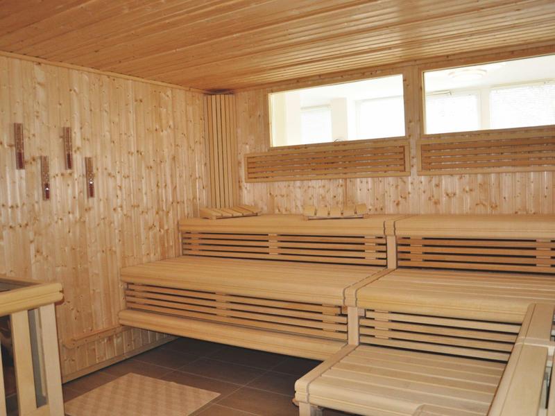 Innenansicht einer finnischen Sauna mit Holzbänken und verglasten Fenstern