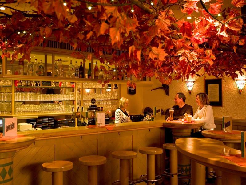 Gemütliche Hotelbar mit herbstlicher Dekoration und Gästen am Tresen