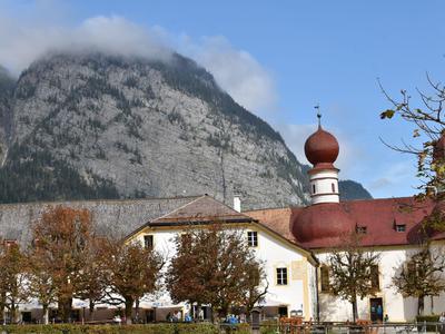 Blick auf ein Gebäude mit Zwiebelkuppeln vor bewaldeten Bergen und blauen Himmel