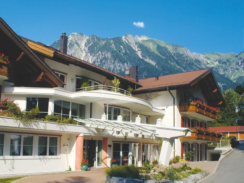 Edificio dell'hotel davanti a uno scenario montano sotto un cielo sereno