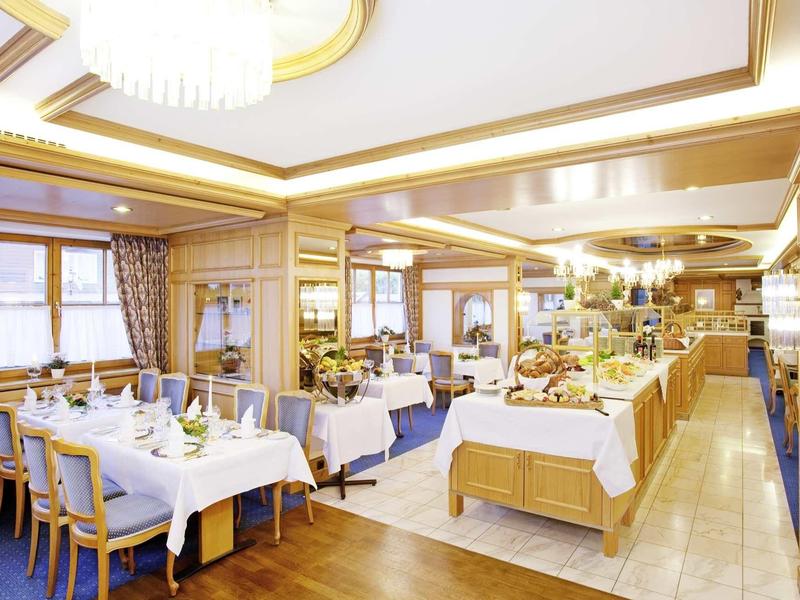 Bright, elegant restaurant with set tables and buffet area.