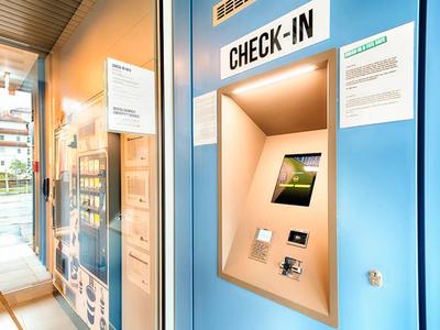 Moderní samoobslužný přihlašovací automat v dobře osvětleném vstupu do hotelu.