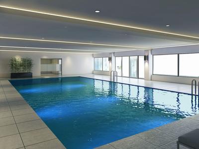 Moderner Innenpool mit klarem Wasser, großen Fenstern und hellen Deckenleuchten in elegantem Raum.