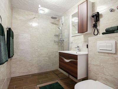 Modernes Badezimmer mit Dusche, Waschbecken, Toilette und handtüchern.