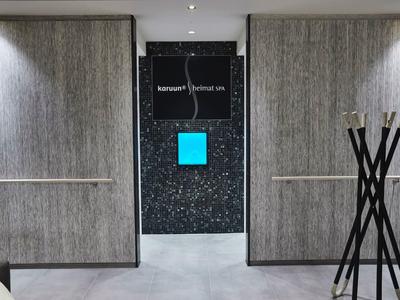 Nowoczesny korytarz hotelowy z minimalistycznym wystrojem i dekoracyjnym stojakiem.