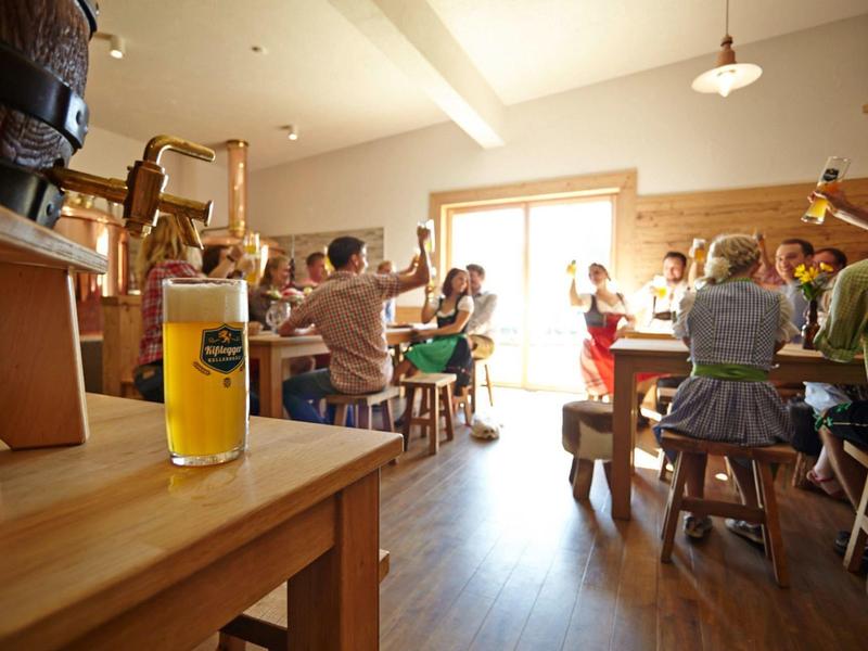 Goście wznoszą kieliszki w przytulnym barze lub restauracji w świetle dziennym.