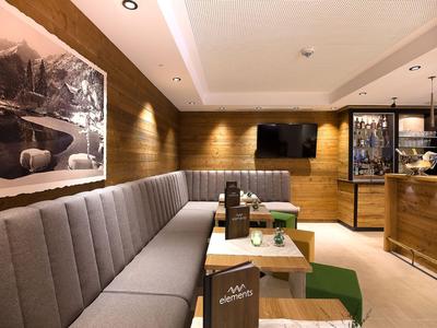 Modern eingerichteter Hotel-Lounge-Bereich mit grauer Eckbank, Holzwänden und Fernseher.