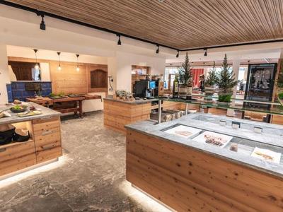 Interieur van een modern hotel met houten plafond, verlichte toonbanken en kerstdecoraties.