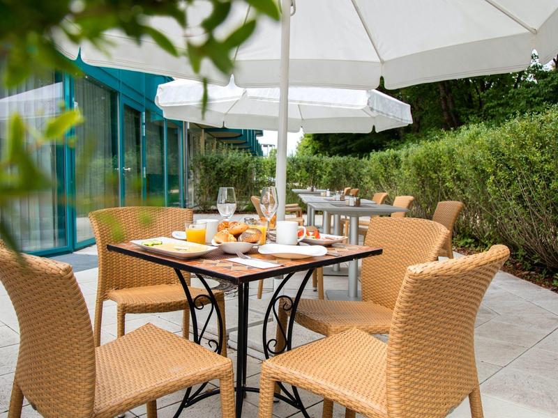 Terrazza con tavolo, sedie, ombrellone, colazione e bevande servite.