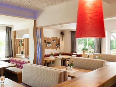 Restaurant moderne et lumineux avec des banquettes confortables et de grands abat-jours rouges