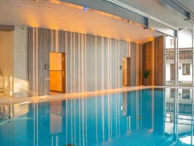 Moderner Innenpool mit großen Fenstern und entspannter Atmosphäre in einem Hotel.