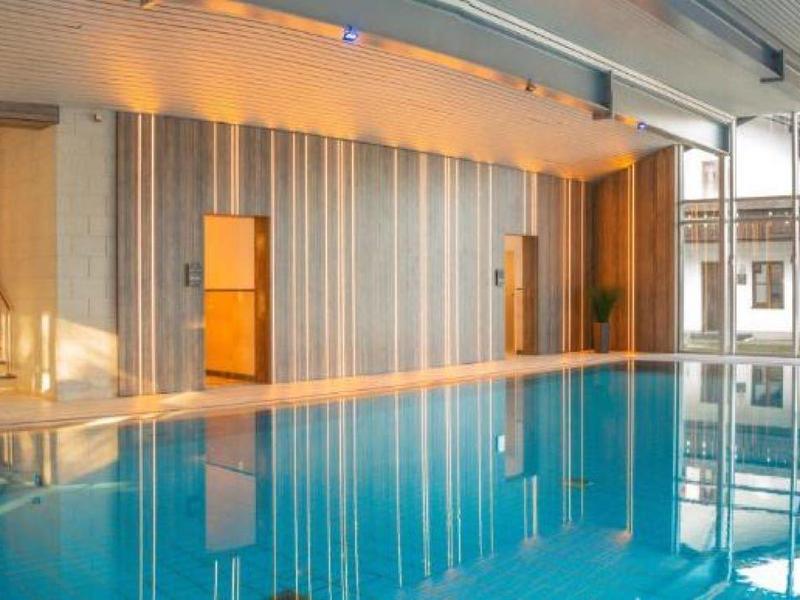 Moderner Innenpool mit großen Fenstern und entspannter Atmosphäre in einem Hotel.