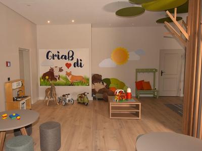 Gezellige speelkamer voor kinderen met koeienafbeeldingen en houten vloer in een hotel.