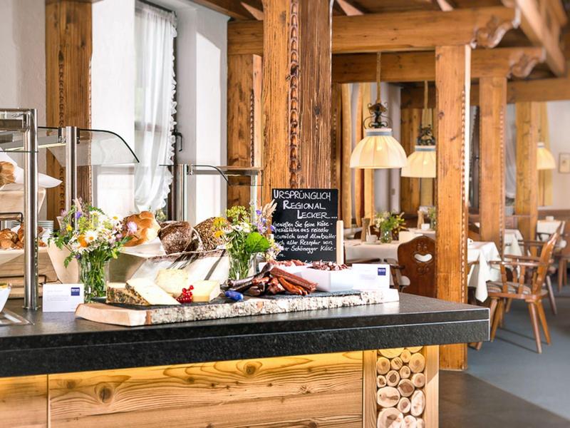 Gezellig café met rustiek houten interieur en ontbijtbuffet met specialiteiten.