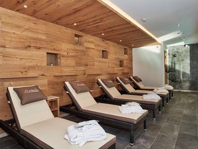 Moderne ontspanningsruimte met ligstoelen en houten wand in een wellnessruimte.