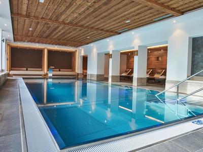 Moderne binnenzwembad met houten plafond en grote ramen in een hotel.