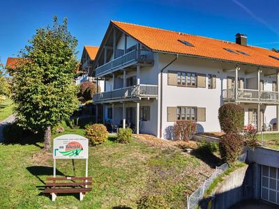 Grande edificio dell'hotel con tetto rosso e balcone in un paesaggio verde sotto un cielo limpido.