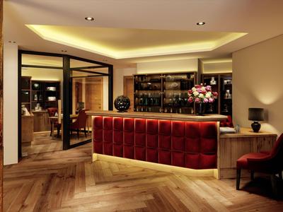 Hall d'hôtel élégant avec comptoir rouge et éclairage moderne.