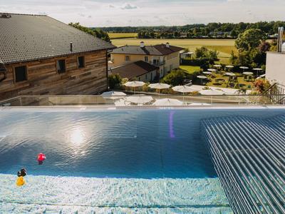 Modernes Außenpool mit Liegestühlen und Sonnenschirmen bei Hotel in ländlicher Umgebung