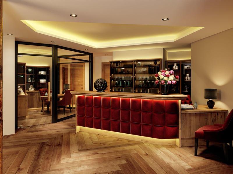 Modern gestalteter Hotelempfang mit rotem Empfangstresen und eleganter Beleuchtung.