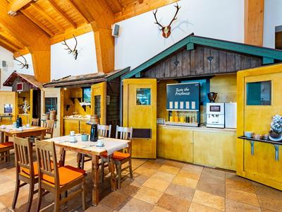 Bar acogedor de hotel en estilo rústico con muebles de madera y astas de ciervo decorativas en la pared.