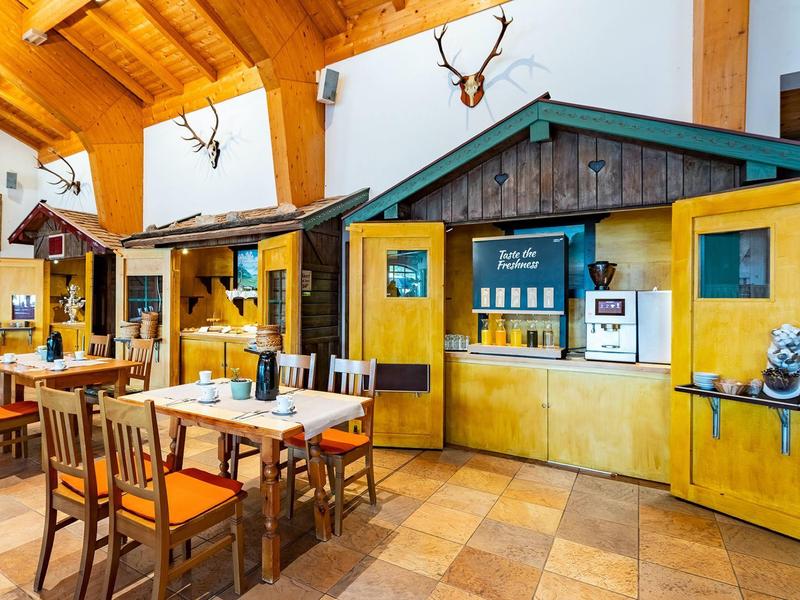 Cozy dining area with wooden furniture and hunting decor in warm colors.