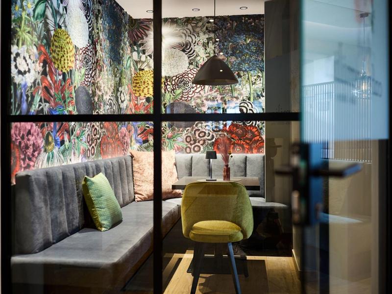 Przytulny kącik z kolorową sztuką na ścianie i nowoczesnymi meblami w pokoju hotelowym.