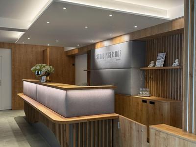 Moderner Hotel-Empfangsbereich mit Holzvertäfelung und Beleuchtung an der Decke.