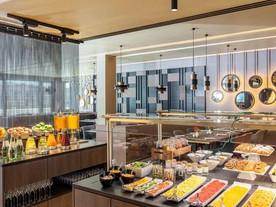 Strefa bufetu z wyborem dań śniadaniowych i napojów w nowoczesnym hotelu.