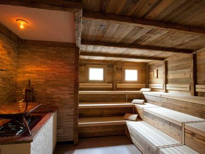 Eine Holzsauna mit mehrstufigen Sitzbänken und warmem, holzgetäfeltem Innenraum.