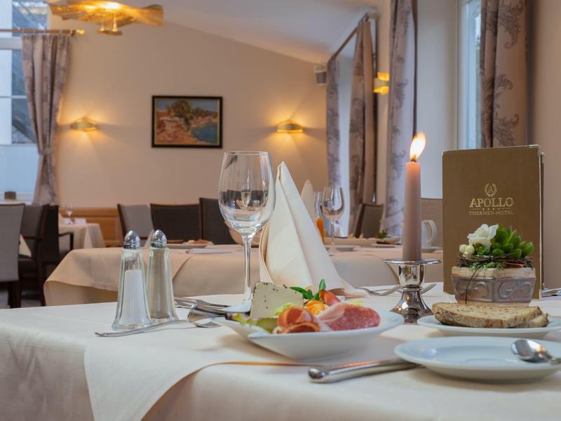 Ristorante elegante con tavolo apparecchiato, candela e piatto con antipasto.