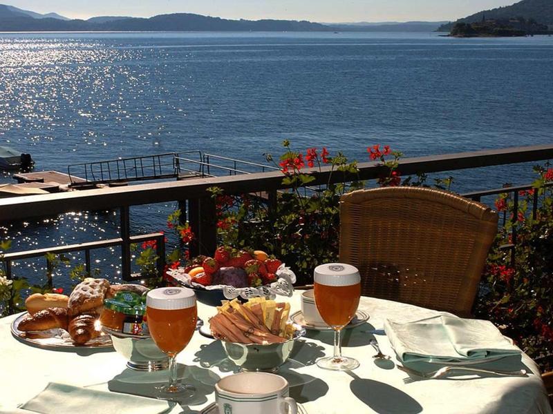 Tafel op een terras met bier, snacks en uitzicht op zee op een zonnige dag.