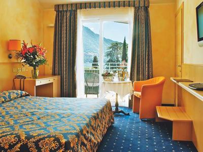 Gemütliches Hotelzimmer mit Doppelbett, Balkon und Bergblick bei Tageslicht.