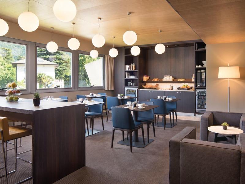 Modern ingericht hotel lounge met tafels, stoelen en grote ramen.